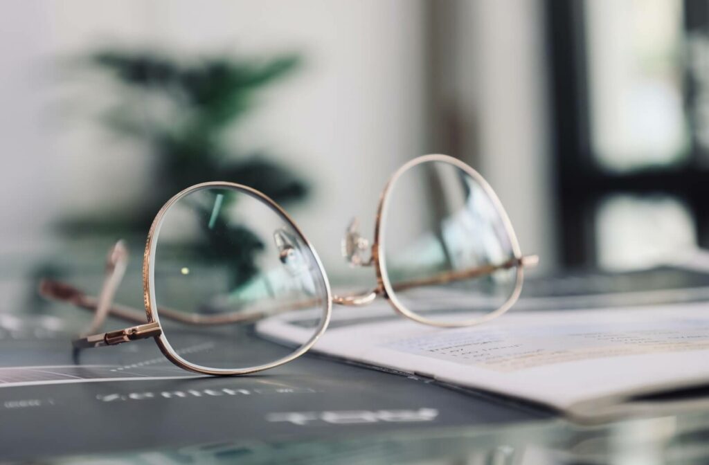 Round progressive eyeglasses resting on an open book, representing multifocal vision correction for reading and everyday tasks.